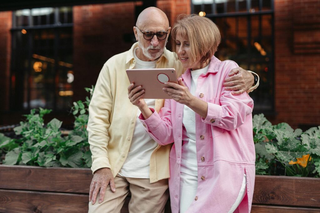 Senior couple researching Medicare plans on a tablet, engaging with valuable content for Medicare leads.