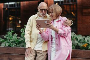 Senior couple researching Medicare plans on a tablet, engaging with valuable content for Medicare leads.
